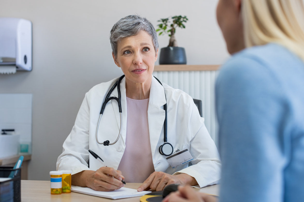 Older female doctor talking to a younger female patient