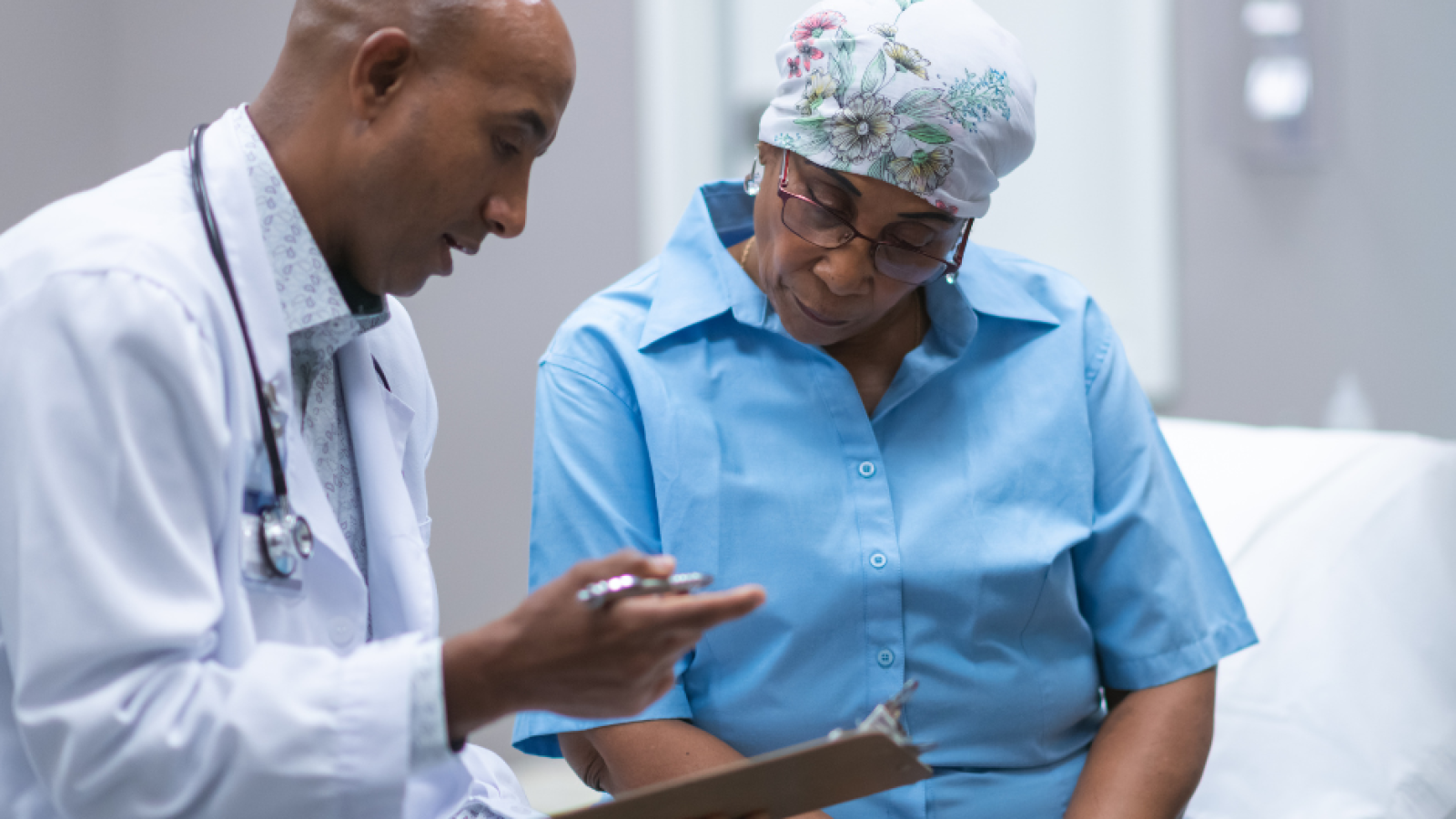 older black woman breast cancer patient speaking with black male doctor