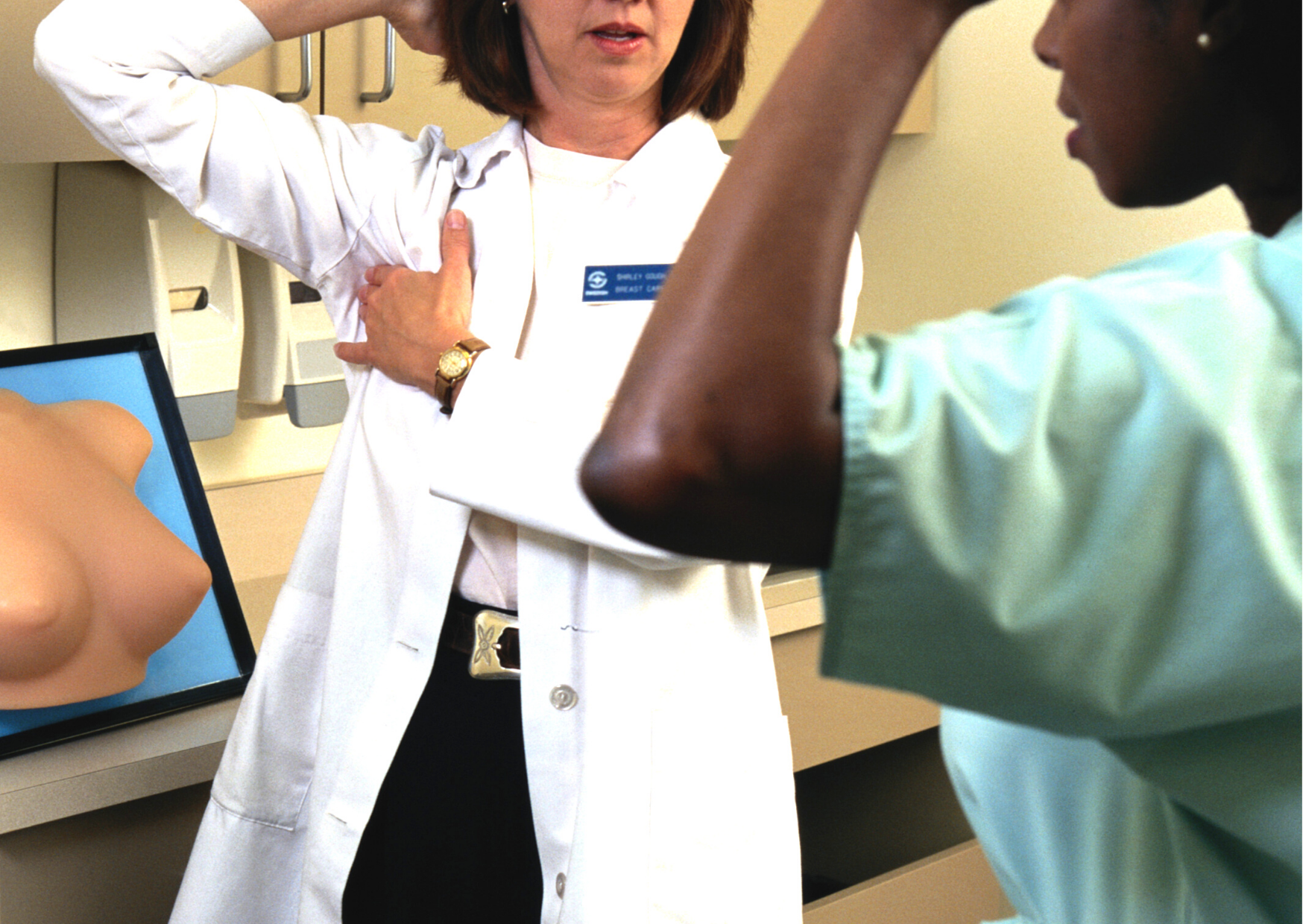 white female nurse gives black female patient breast self-exam lesson