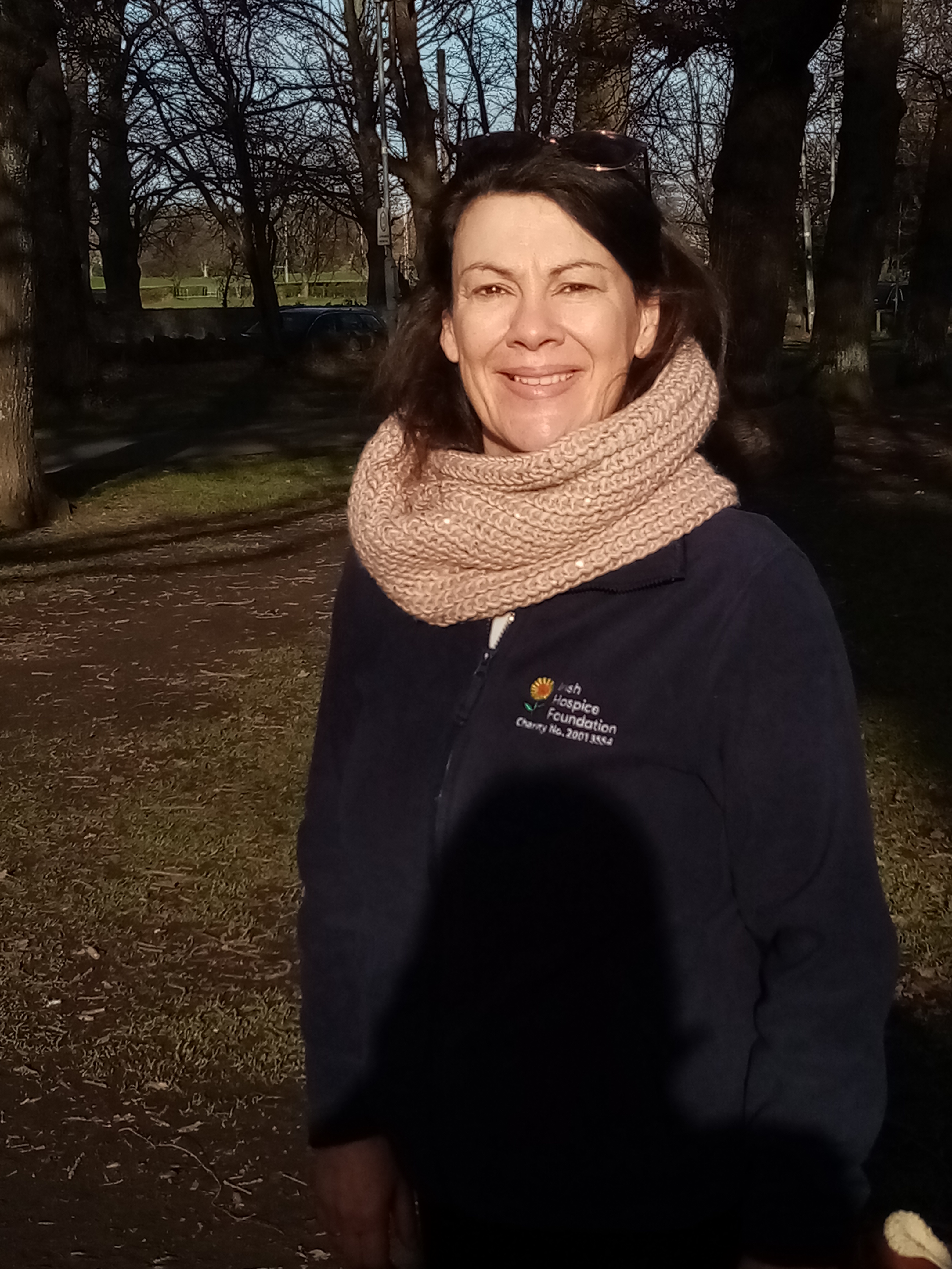 Annmarie is outdoors, she smiles directly to the camera