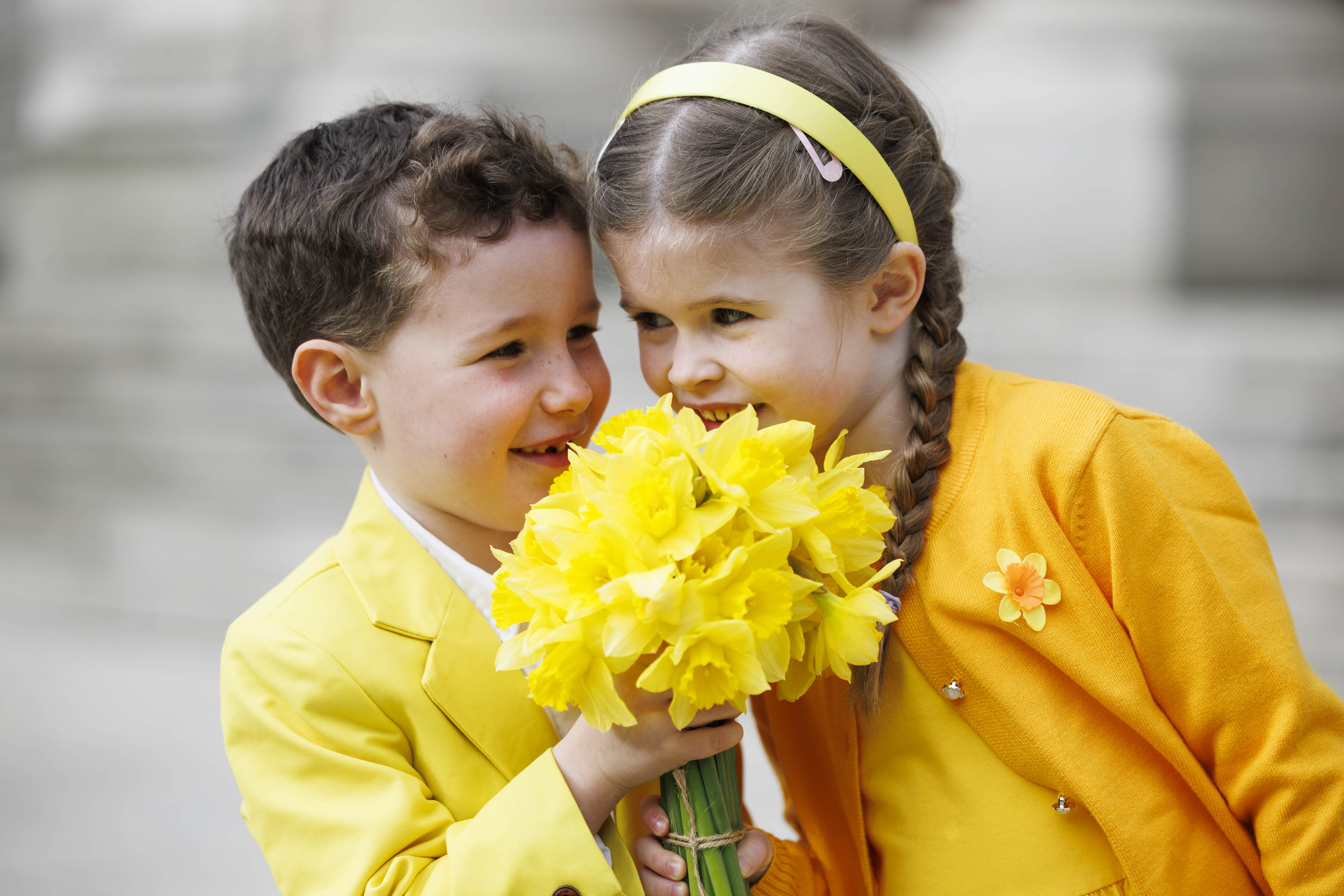 Kids dressed in yellow holding daffodils