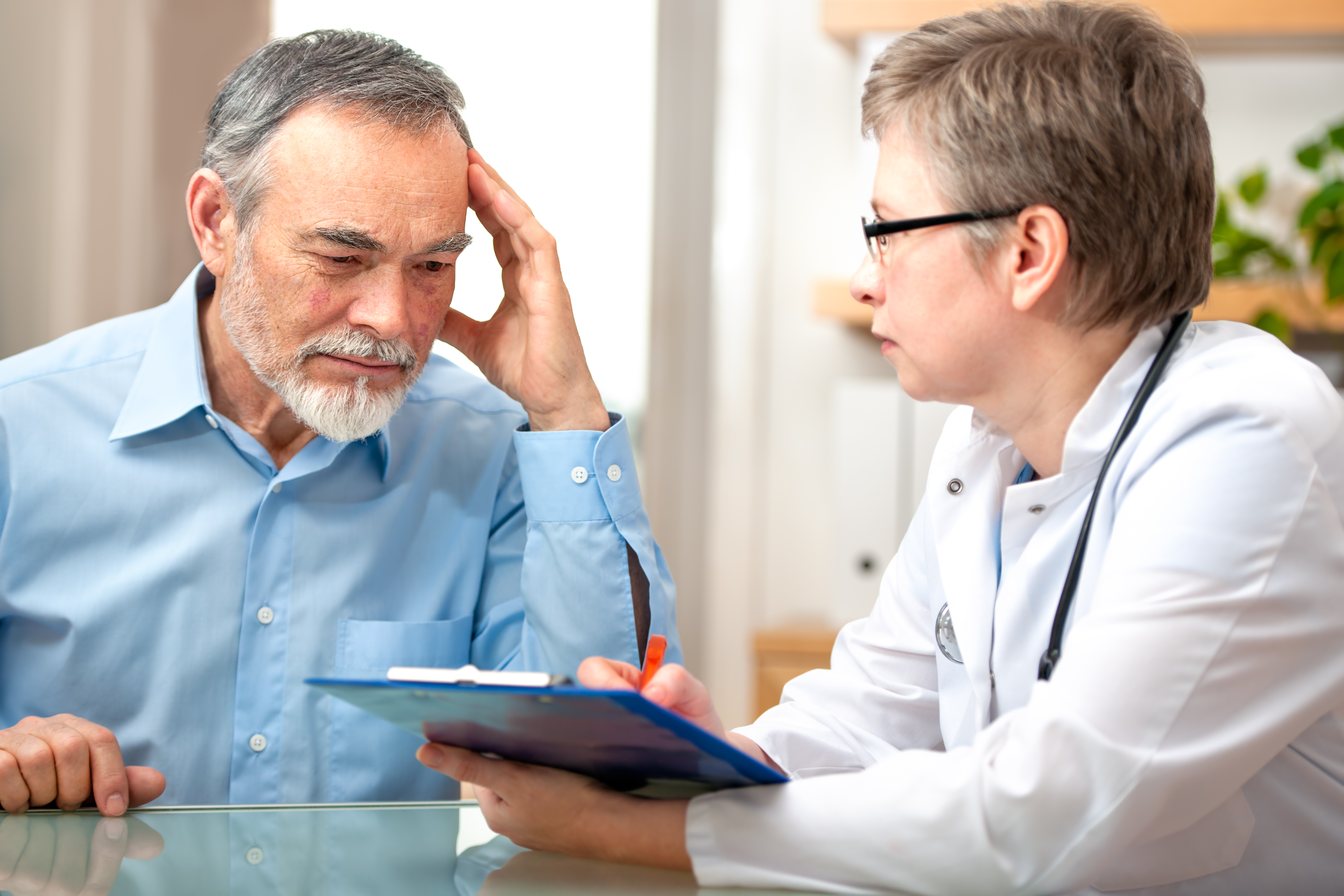 Male patient looking seriously sitting with a doctor