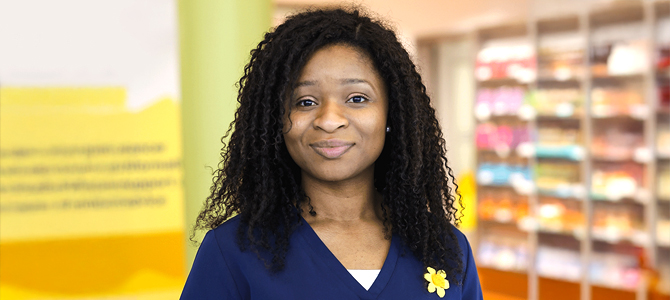 Nurse in navy tunic smiling to camera