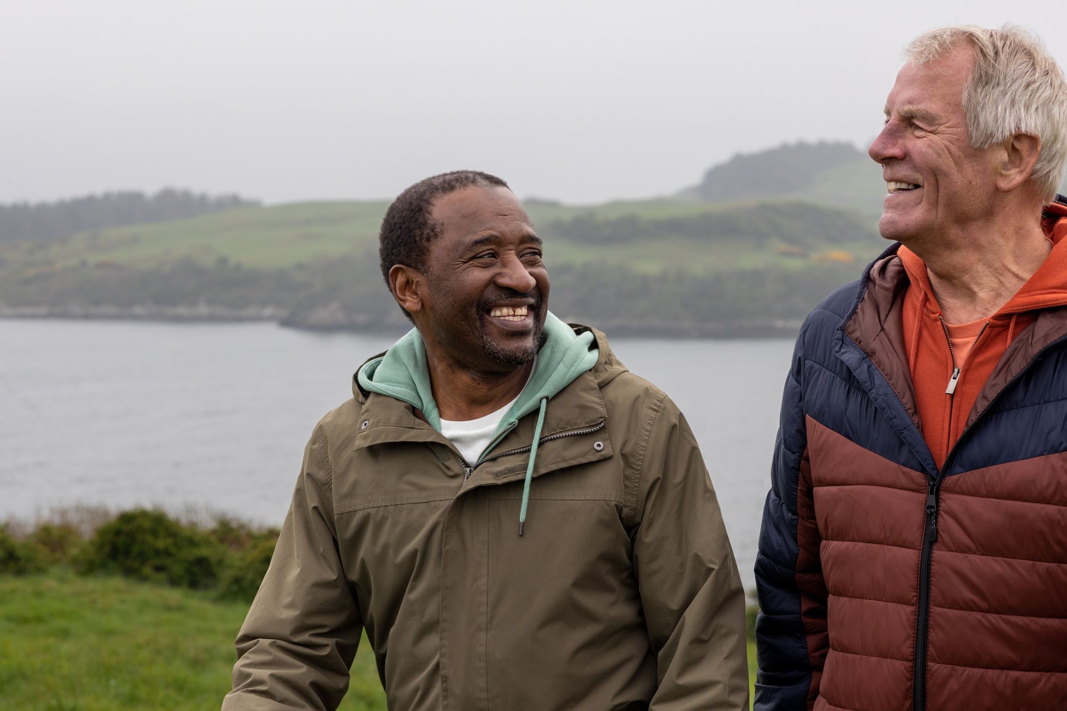 One black and one white middle aged man on rainy walking holiday