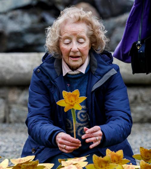 Woman with paper daffodil in Garden of Hope