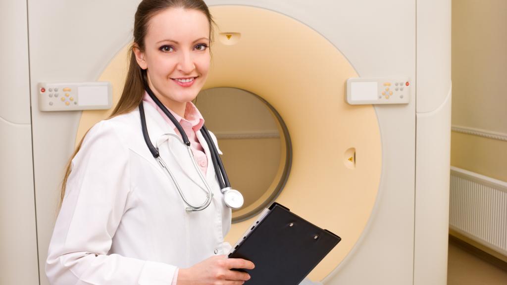 Doctor standing in front of a radiotherapy machine