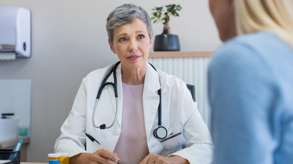 Older female doctor talking to a younger female patient