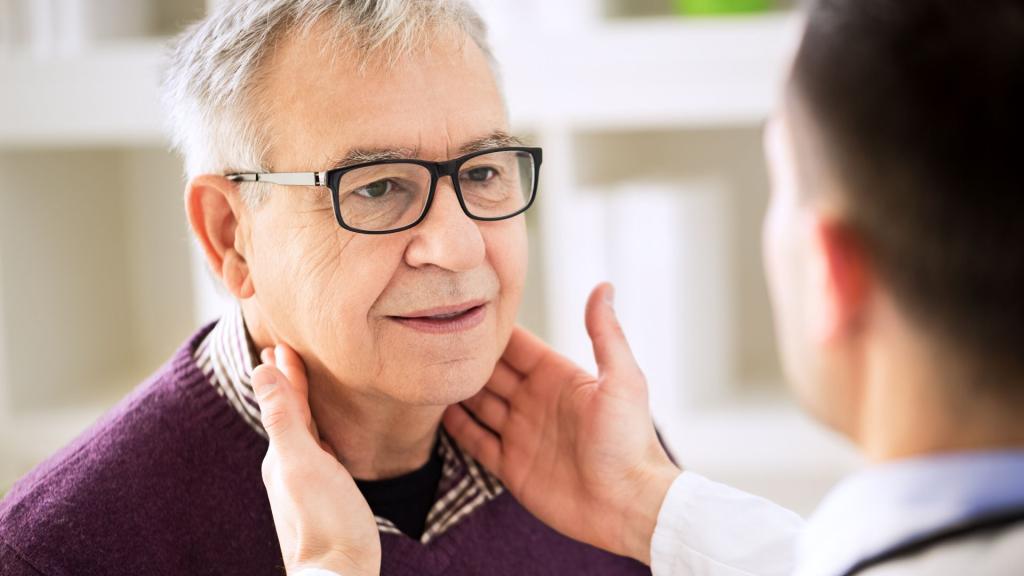 Doctor touching man's throat