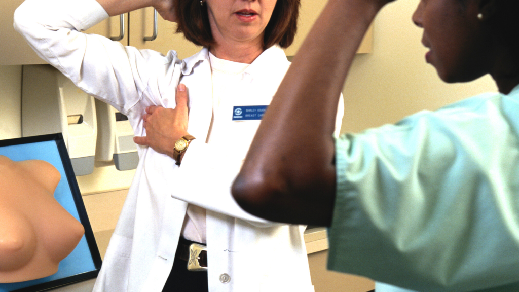 white female nurse gives black female patient breast self-exam lesson