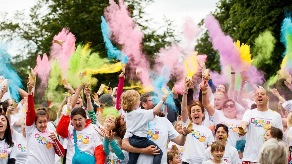 A collection of people throwing colour dash paint in the air