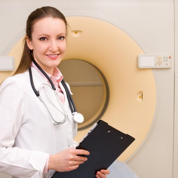 Doctor standing in front of a radiotherapy machine