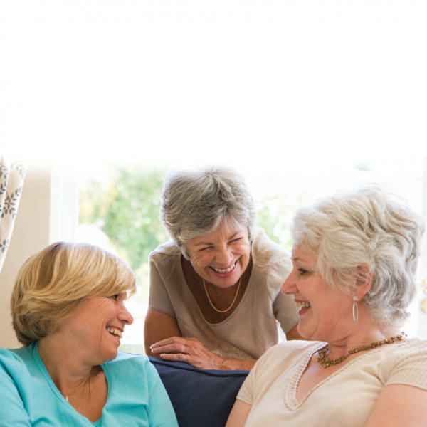 Trio of older women smiling and talking