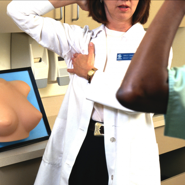 white female nurse gives black female patient breast self-exam lesson