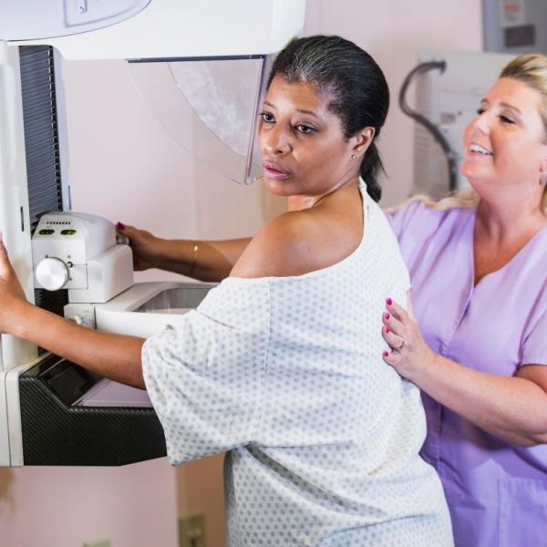 black middle-aged woman having mastectomy with white nurse