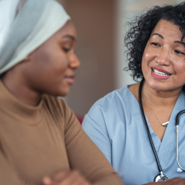 post-chemo younger black breast cancer patient talking to female nurse