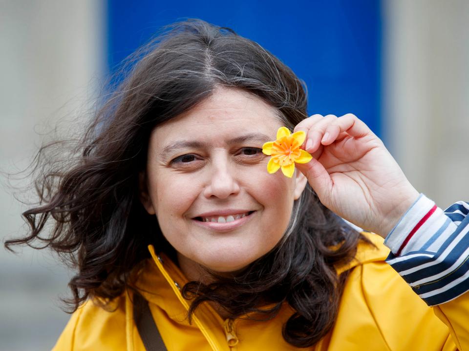 Woman holding a daffodil pin