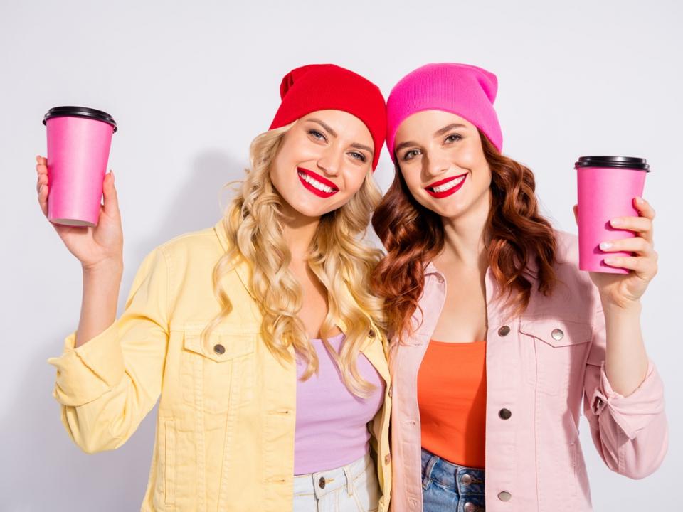 Two women holding pink coffee mugs