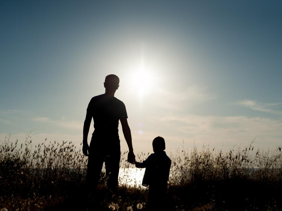 Father and son walking into the sunset