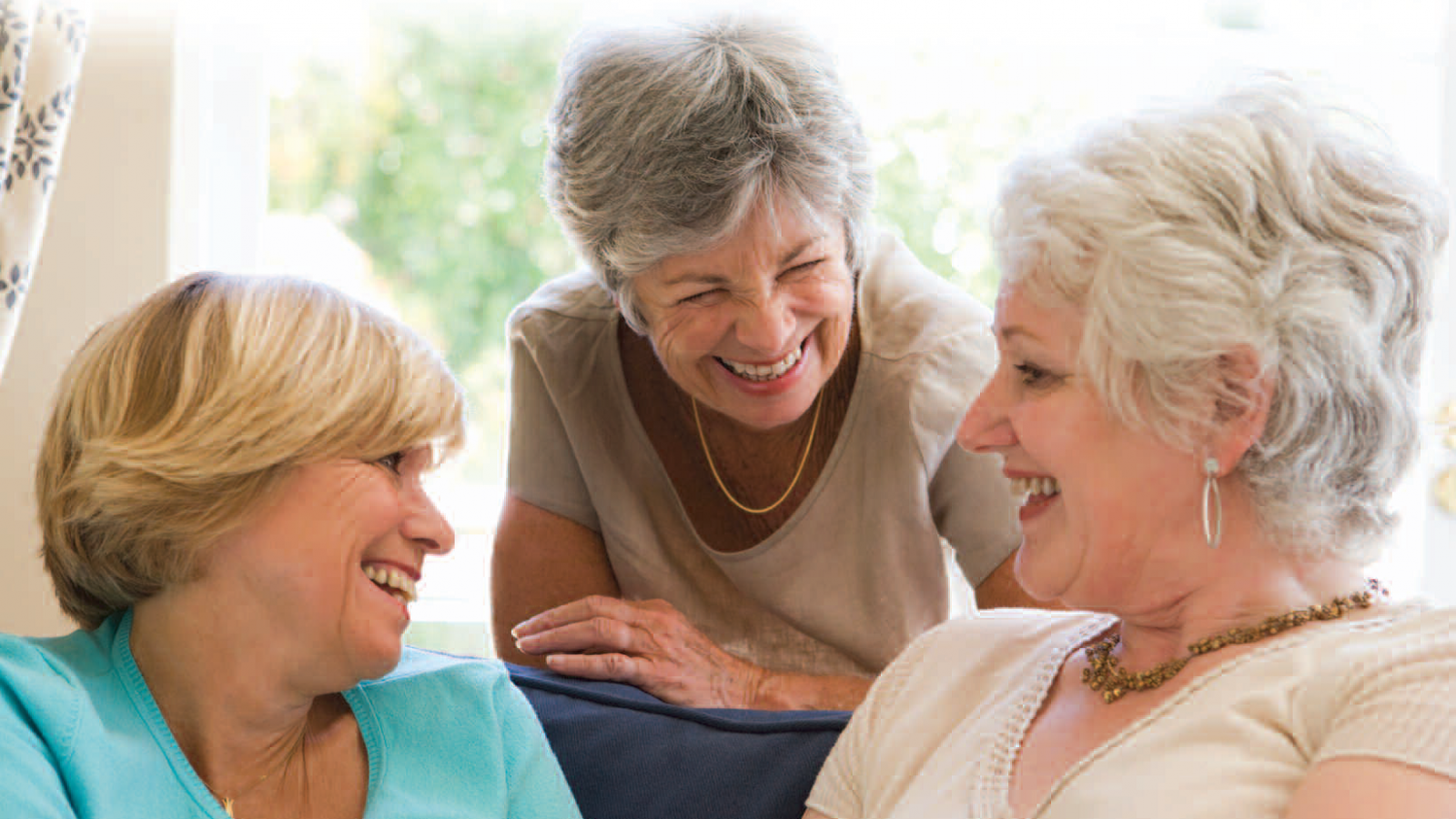 Trio of older women smiling and talking