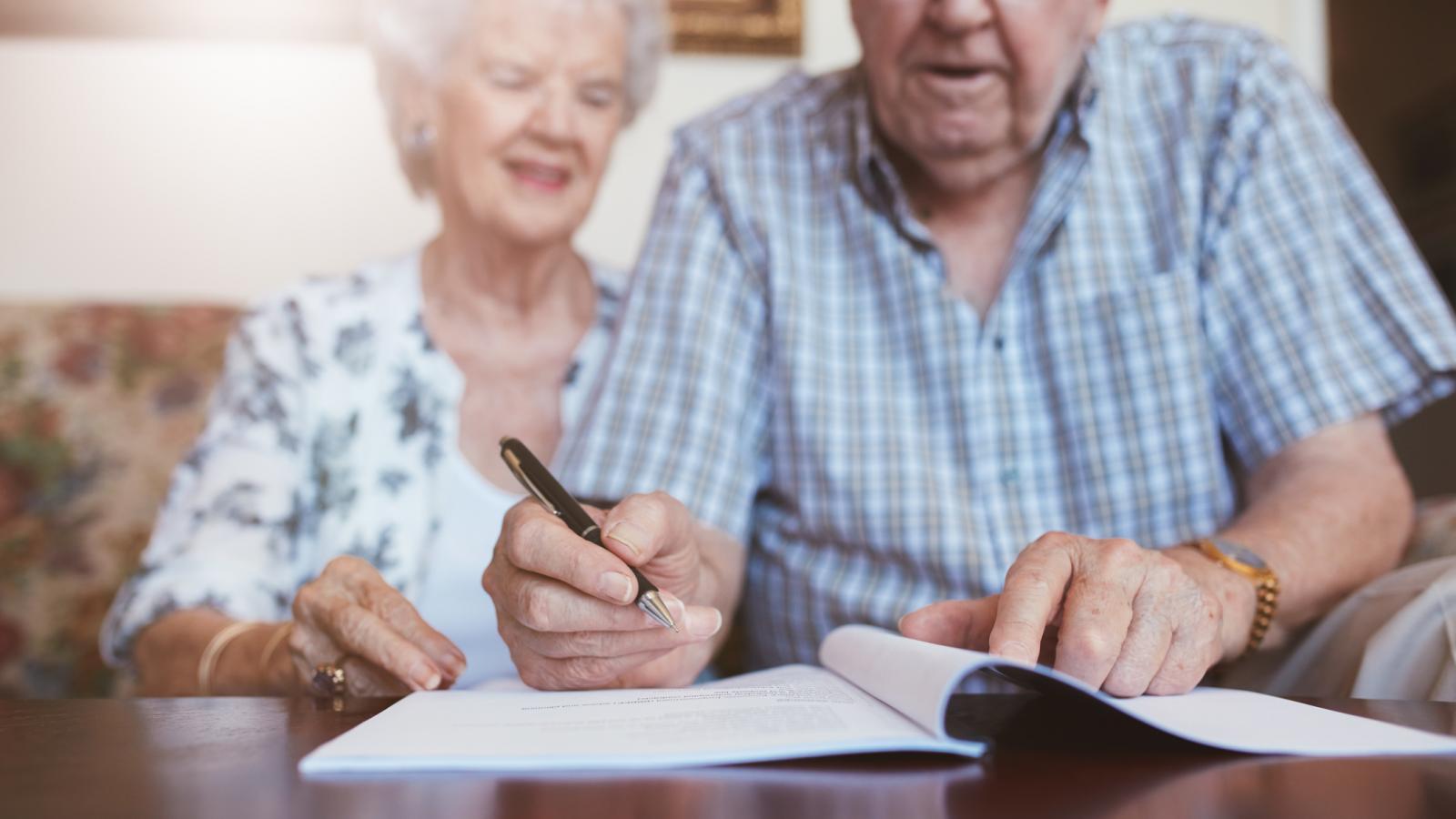 Older couple signing documents
