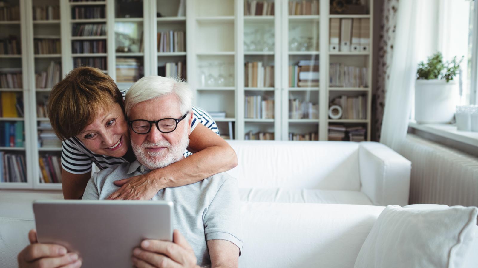 Older couple on couch looking at tablet