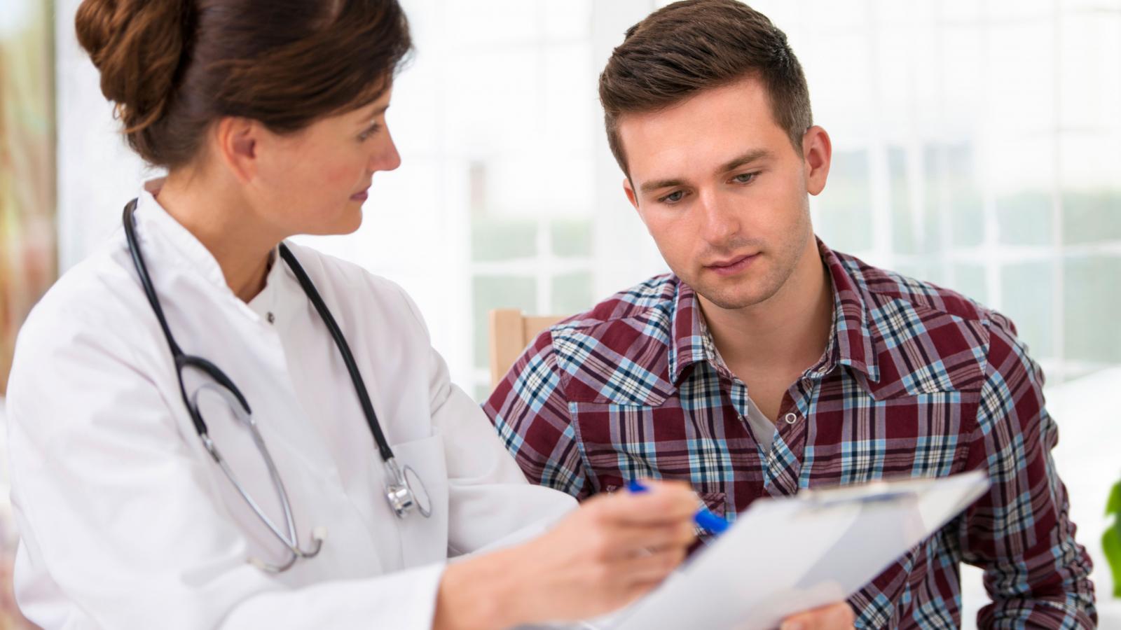Female doctor explaining something to a young male patient