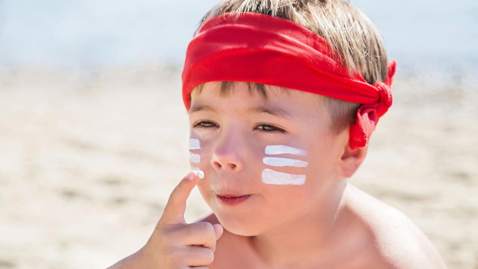 Boy applying sunscreen