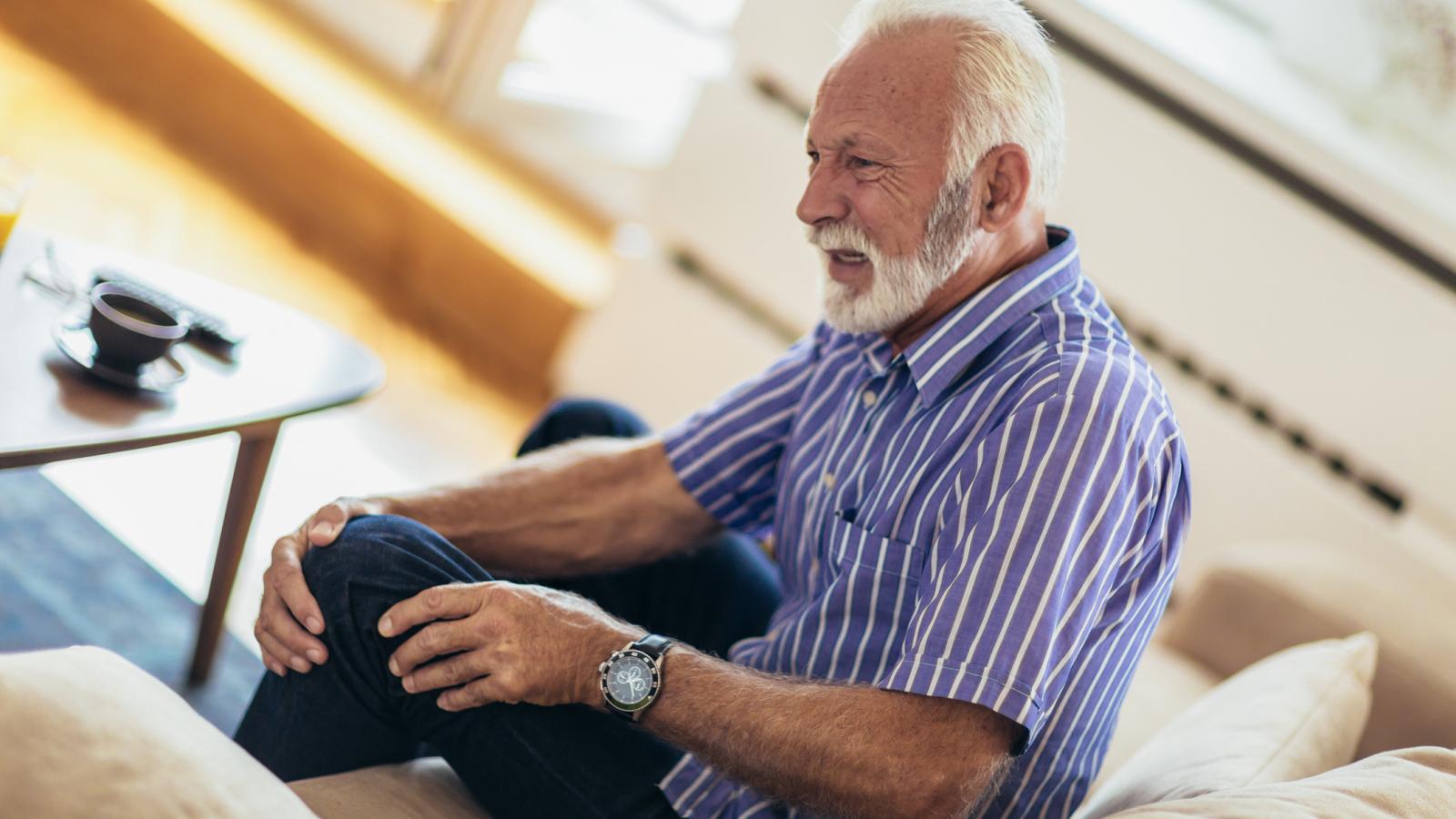 Older man touching his knee