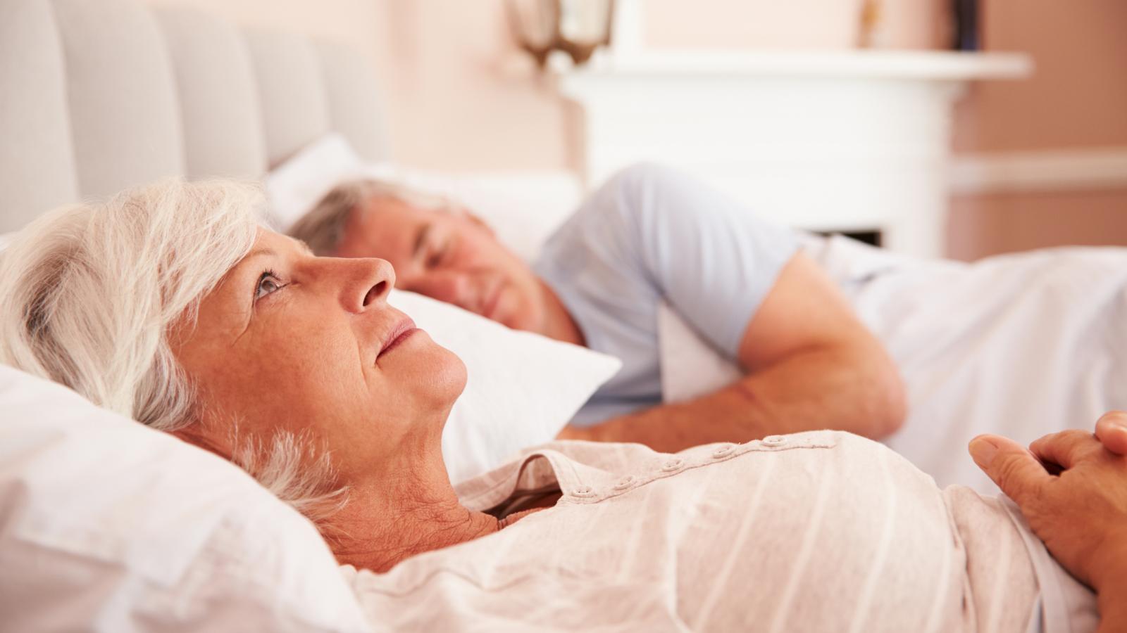 Older couple laying awake in bed