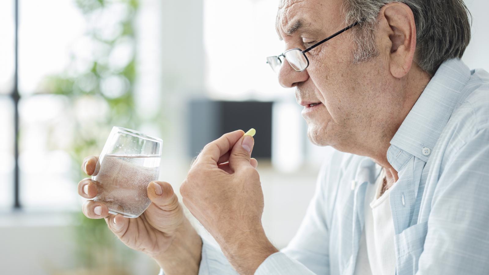 Older man taking a tablet