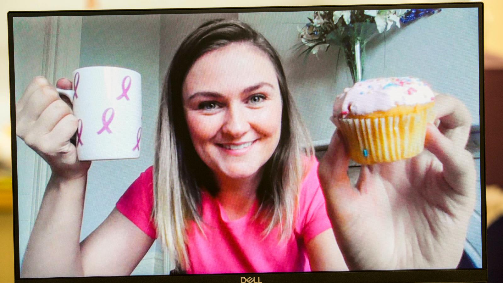 woman holding up mug and muffin