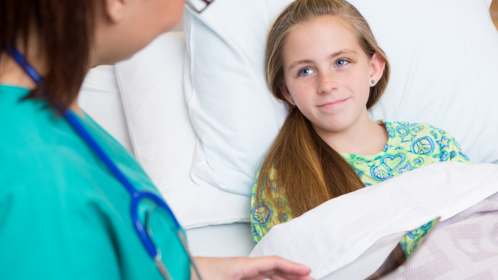 A girl in a hospital bed with a nurse