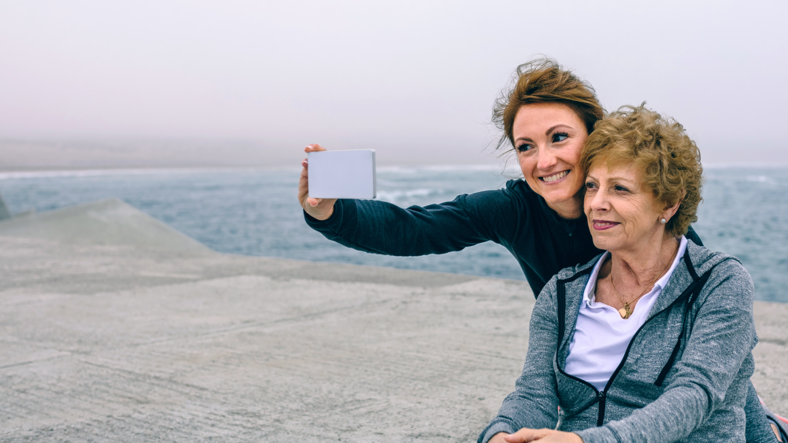 Older woman with daughter taking selfie Canva