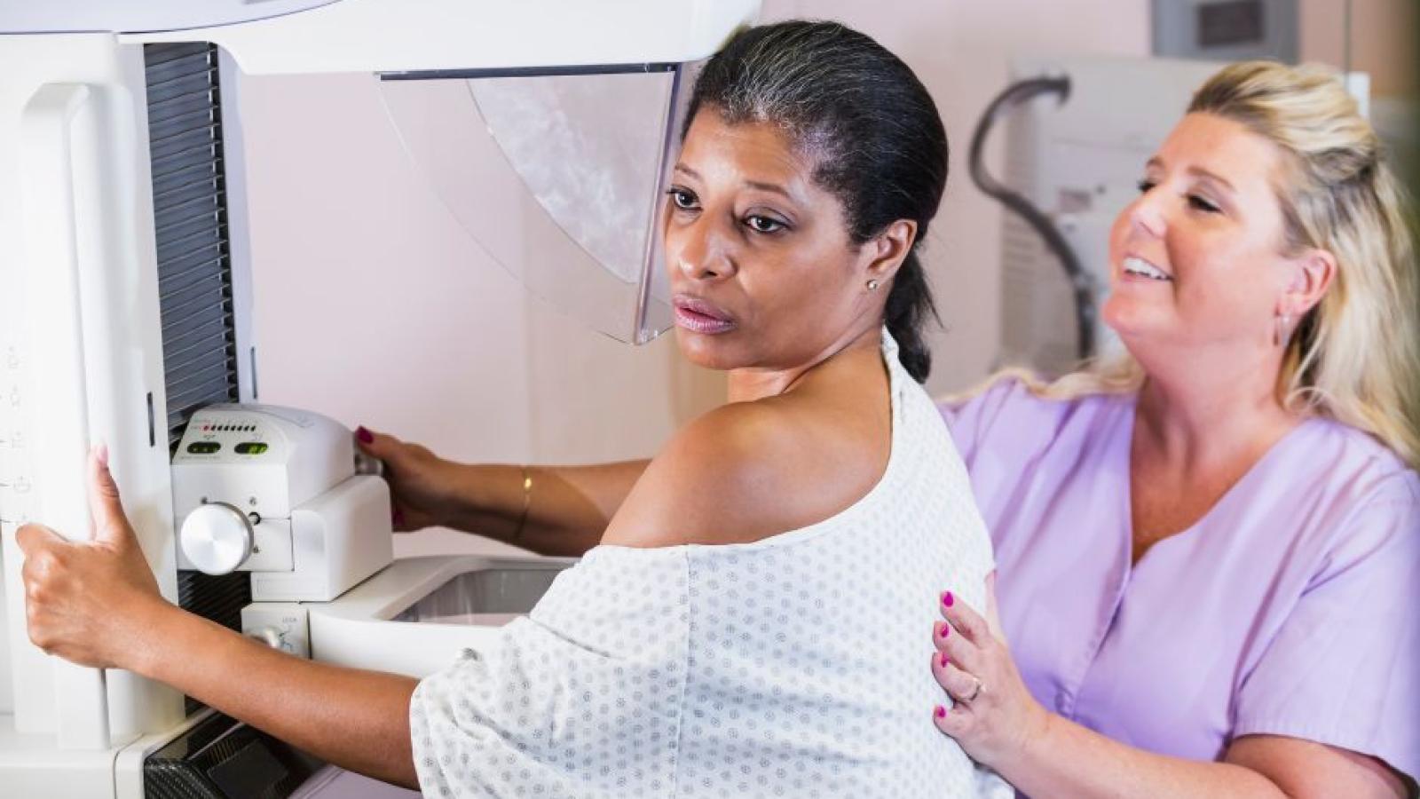 black middle-aged woman having mastectomy with white nurse