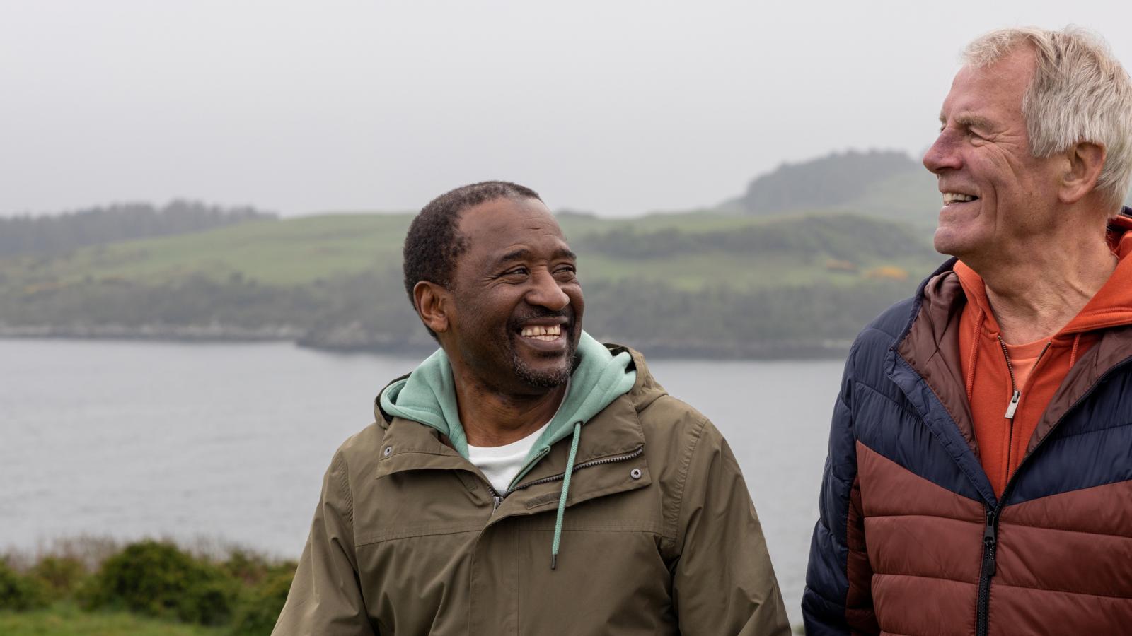 One black and one white middle aged man on rainy walking holiday
