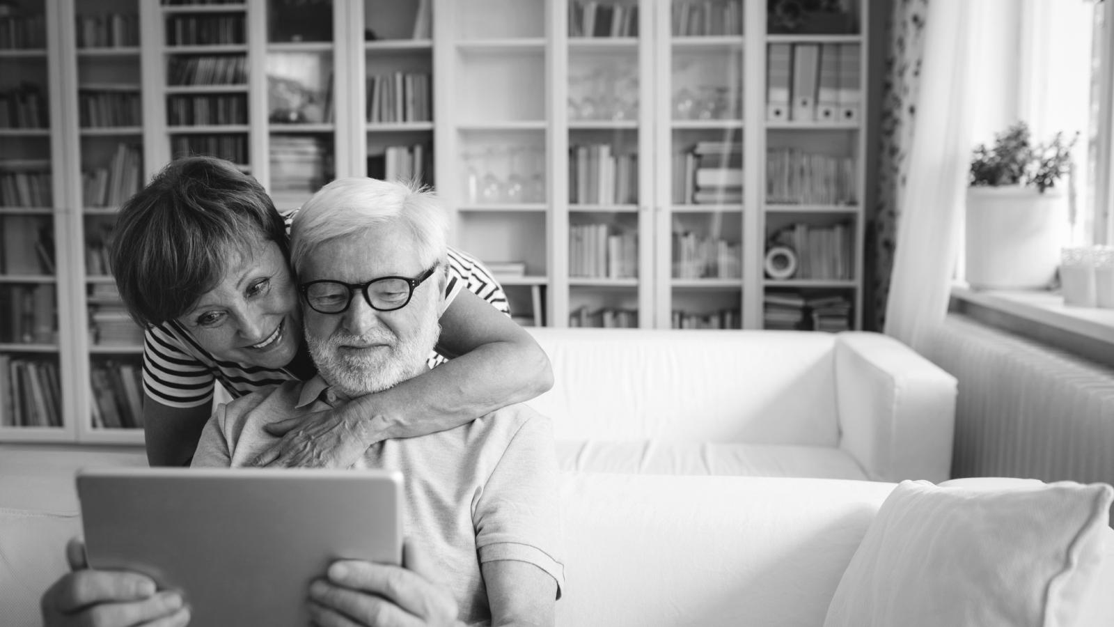 Older couple on couch looking at tablet