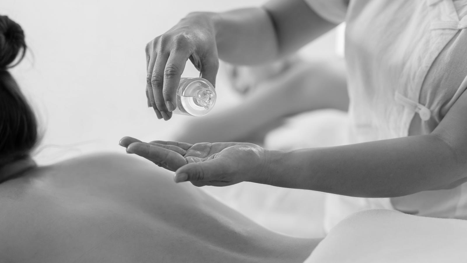 Massage oil being poured onto a person's back